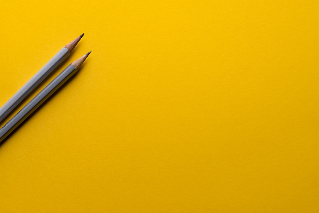 deux-crayons-gris-sur-surface-jaune